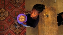 In this photo taken on Thursday, Nov. 14, 2019, children share a meal they received from a government sponsored feeding scheme at the Delta Primary School in Vosburg, South Africa. (AP Photo/Denis Farrell)