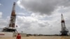 Un trabajador de un campo petrolero camina junto a las plataformas de perforación en un pozo petrolero operado por la petrolera estatal venezolana PDVSA, en la rica franja del Orinoco, el 16 de abril de 2015.
