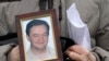 FILE - A portrait of lawyer Sergei Magnitsky who died in jail, is held by his mother Nataliya Magnitskaya, Nov. 30, 2009, as she speaks during an interview with the AP in Moscow, Russia. 