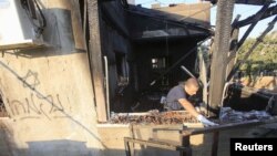 Seorang polisi Israel memeriksa rumah yang rusak terbakar oleh para ekstremis Yahudi di desa Kafr Duma dekat kota Nablus di Tepi Barat (31/7). 