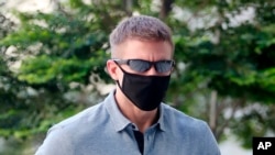លោក Brian Dugan Yeargan ពាក់​ម៉ាស់ និង​វែនតា​ការពារ​កម្តៅ​ថ្ងៃ​ដើរ​នៅ​ខាង​ក្រៅ​តុលាការ​រដ្ឋ​សិង្ហបុរី ក្នុង​ប្រទេស​សិង្ហបុរី កាលពី​ថ្ងៃទី១៣ ខែឧសភា ឆ្នាំ២០២០។