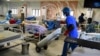 Un responsable de la santé pousse une bouteille d'oxygène sur un chariot pour traiter des patients atteints de COVID-19 souffrant de problèmes respiratoires aigus dans un service du centre d'isolement de l'État de Lagos à Yaba, Lagos, le 22 janvier 2021.