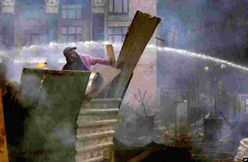 An anti-government protester throws a Molotov cocktail during clashes with riot police, Independence Square, Kyiv, Ukraine, Feb. 19, 2014.