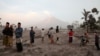 Grupos de personas observan la erupción del volcám Semeru en Indonesia el 5 de diciembre de 2022.