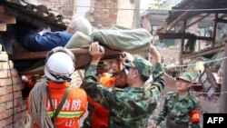 Regu penolong membantu seorang lansia keluar dari rumahnya yang hancur akibat gempa berkekuatan 7.0 yang mengguncang wilayah Qingren, Lushan di propinsi Sichuan, Chian (20/4).