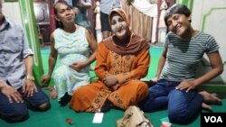 Ibu Shinta (center) is seen surrounded by students at Indonesia's only Islamic school for transgender students, which she runs out of her house in Yogyakarta. (K. Varagur/VOA)