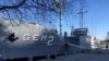 FILE - A North Korean military security guard keeps watch over the USS Pueblo in Pyongyang, North Korea, Jan. 24, 2018.