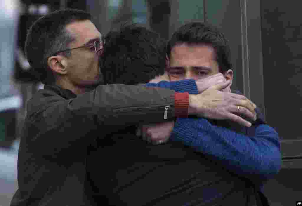 Family members of people involved in a crashed plane comfort each other as they arrive at the Barcelona airport in Spain, March 24, 2015.