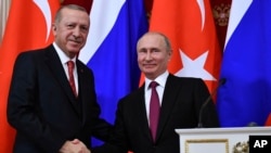 FILE - Russian President Vladimir Putin, right, shakes hands with Turkey's President Recep Tayyip Erdogan after their joint news conference following the talks in the Kremlin in Moscow, Russia, Jan. 23, 2019. 
