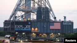 FILE - NASA's Space Launch System mobile launcher rolls on a crawler-transporter for months of testing before the launch of Artemis 1 at the Kennedy Space Center in Cape Canaveral, Florida, June 27, 2019. 
