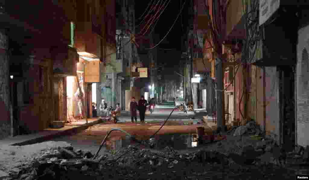 Residents walk along a street in Deir al-Zor, March 9, 2013. 