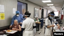 Penghuni panti wreda menerima vaksin virus corona di King David Center, sebuah fasilitas panti jompo, di lingkungan Bath Beach Brooklyn di New York City, 6 Januari 2021. (Foto: Reuters)