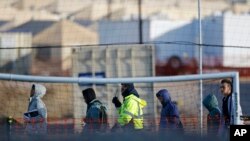FILE - Teen migrants walk in line inside the Tornillo detention camp in Tornillo, Texas, Dec. 13, 2018.