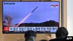 24일 한국 서울 시내 철도역 이용객들이 북한 순항미사일 발사 관련 TV 뉴스를 시청하고 있다.