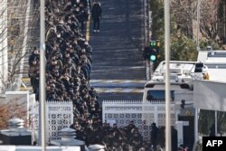 Policajci i istražitelji napuštaju rezidenciju opozvanog južnokorejskog predsjednika Yoon Suk Yeola u Seulu, 15. januara 2025.