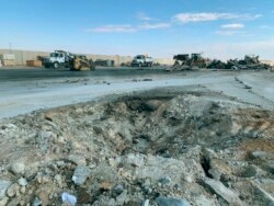 FILE - A crater is seen at Ain al-Asad air base, in Anbar, Iraq, Jan. 13, 2020, following an Iranian missile attack.