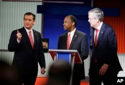 Republican presidential candidates Sen. Ted Cruz, left, retired neurosurgeon Ben Carson and former Florida Gov. Jeb Bush chat during the Fox Business Network Republican presidential debate in North Charleston, S.C., Jan. 15, 2016.
