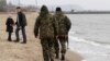 File - Local volunteers patrol the city beach in Mariupol, Donetsk region of Ukraine.