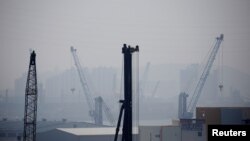 FILE - Cranes are seen on a polluted day in Incheon, South Korea, May 30, 2016. 