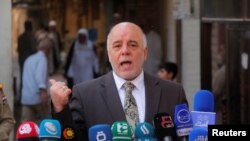 FILE - Iraqi Prime Minister Haider al-Abadi speaks to reporters in the Shi'ite holy city of Najaf, south of Baghdad.