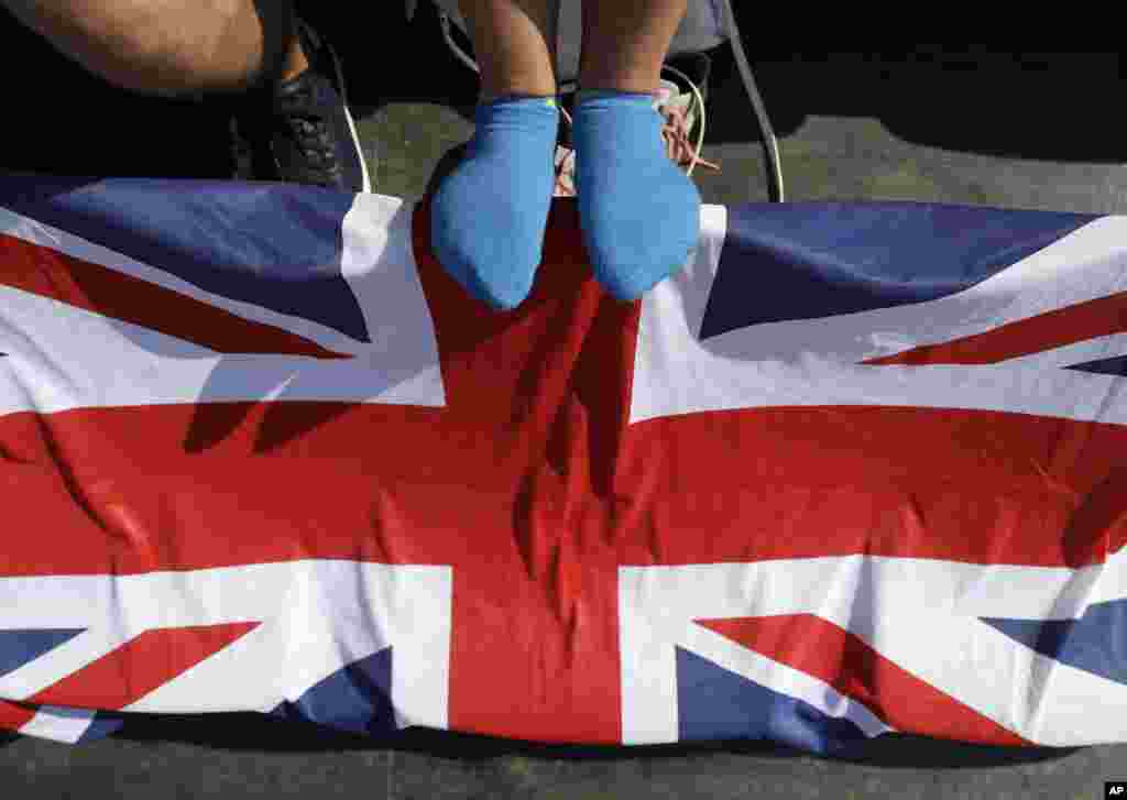 A British fan rests her feet on flag-draped seats during the equestrian eventing dressage competition at the 2016 Summer Olympics in Rio de Janeiro, Brazil, Aug. 6, 2016.