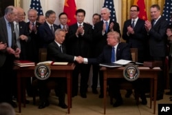 Predsjednik Donald Trump i kineski zamjenik premijera Liu He rukuju se nakon potpisivanja "prve faze" trgovinskog sporazuma između SAD-a i Kine, u istočnoj sobi Bijele kuće, 15. januara 2020. u Washingtonu.