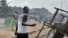 A man holds a machete while angry residents burn tires and block the street where security forces loyal to Ivory Coast's strongman, Laurent Gbagbo, opened fire on demonstrators, killing at least six women, on March 3, 2011 in Abobo, a working class neighb