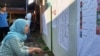 Pemilih memeriksa daftar legislatif yang dipasang di sebuah TPS di Sleman, DIY dalam Pemilu 2019. (Foto:VOA/Nurhadi)