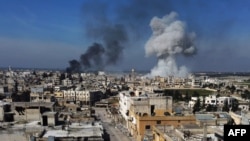 Smoke billows over the town of Saraqib in the eastern part of the Idlib province in northwestern Syria, following bombardment by Syrian government forces, on February 27, 2020-