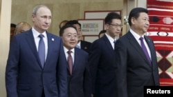 (L-R) Russian President Vladimir Putin, Mongolian President Tsakhia Elbegdorj and Chinese President Xi Jinping arrive for a meeting during the BRICS Summit in Ufa, Russia, July 9, 2015.