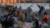 Para penyintas gempa yang kehilangan rumah, berbaris untuk menerima makanan di kamp darurat, di kota Iskenderun, Turki selatan, Selasa, 14 Februari 2023. (AP/Hussein Malla)