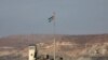 FILE - A picture taken Oct. 18, 2019, from the Israeli side of the border at the Jordan Valley site of Naharayim, shows a Jordanian flag flying over a military outpost. 