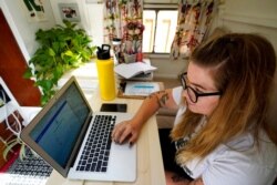 Kelly Mack works on her laptop to teach remotely Sept. 2, 2020, in Evanston, Illinois.