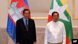 Cambodian Prime Minister Hun Sen, left, poses for photographs together with Myanmar State Administration Council Chairman, Senior General Min Aung Hlaing, right, before holding a meeting in Naypyitaw, Myanmar, Friday, Jan. 7, 2022. (An Khoun SamAun/National Television of Cambodia via AP)