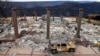 FILE - A vehicle rests in front of a home leveled by the Camp Fire in Paradise, Calif., Dec. 3, 2018. Authorities estimate it will cost at least $3 billion to clear debris of 19,000 homes destroyed by California wildfires last month.