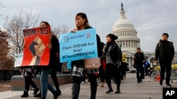FILE - People march in support of the Deferred Action for Childhood Arrivals (DACA) and Temporary Protected Status (TPS) programs, Dec. 5, 2017, on Capitol Hill in Washington. 