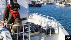 Penjaga pantai Turki tiba dengan jenazat migran yang tenggelam saat berusaha mencapai Yunani, di pelabuhan dekat Izmir, Turki, 21 Januari 2016. 