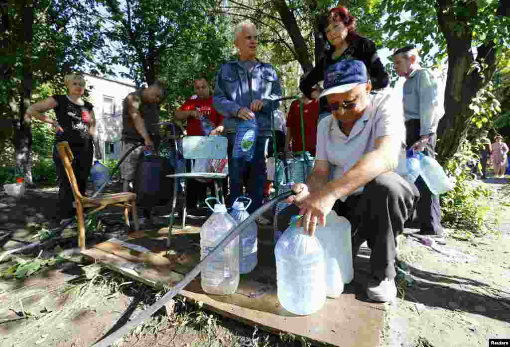 People collect water at a pumping station in the Ukrainian eastern city of Slovyansk, July 1, 2014. 