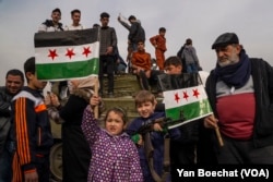 Dijete drži AK-47 jednog od pobunjenika džihadističke grupe Hayat Tahir al-Sham koja je upala u Damask stavljajući tačku na režim Bashara al-Assada, 12. decembra 2024.