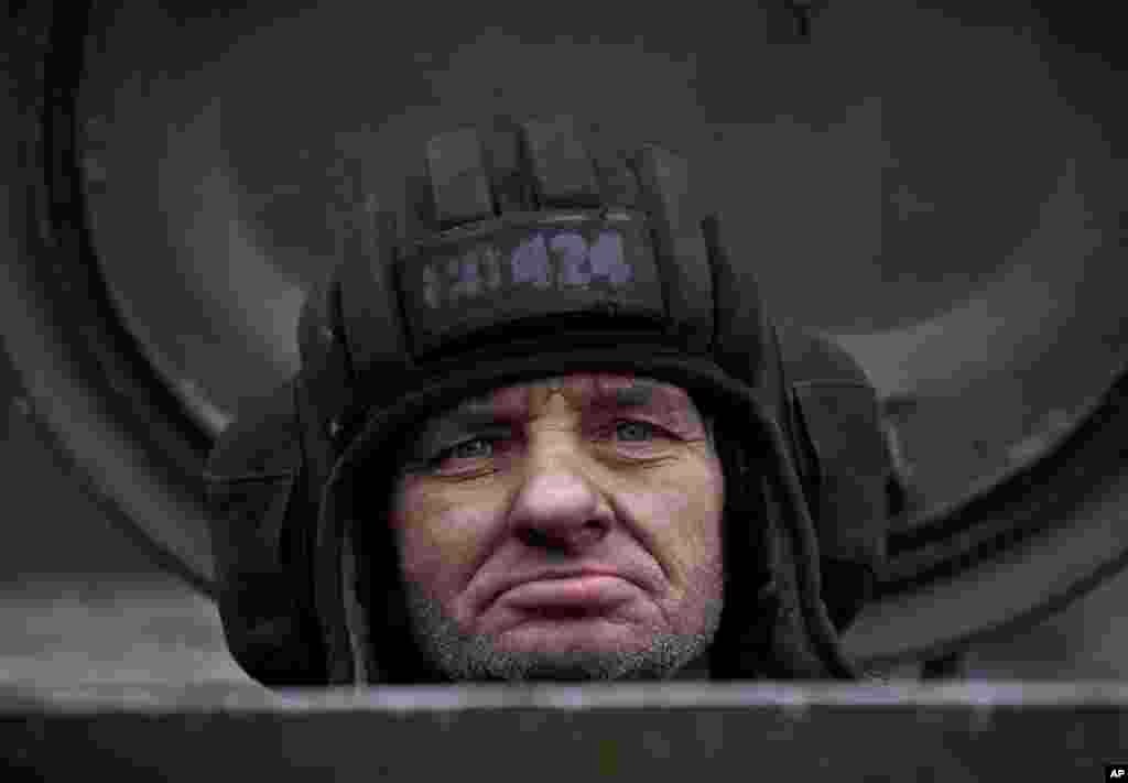 A Russia-backed separatist fighter sits in a self-propelled 152 mm artillery piece, part of a unit that moved away from the front lines, in Yelenovka, near Donetsk, Feb. 26, 2015.