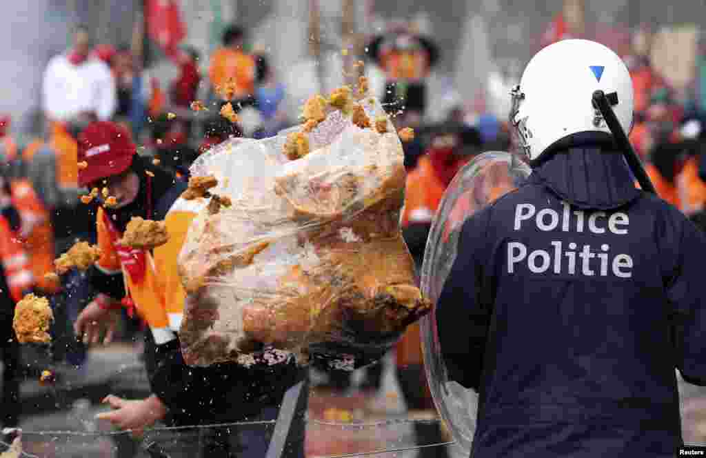 Seorang demonstran melempar sampah kepada polisi anti huru-hara dalam&nbsp; protes Serikat Buruh Eropa terhadap langkah-langkah penghematan, di pusat kota Brussels, Belgia. &nbsp;