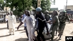 Photo d’archives : Les forces de sécurité aidant à transporter les corps de certaines des 11 victimes d'une double explosion dans la ville camerounaise de Maroua, le 22 juillet 2015.