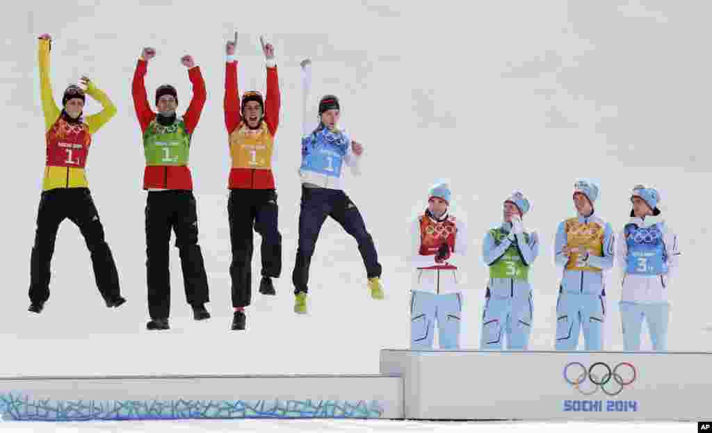 Germany's team Eric Frenzel, Bjoern Kircheisen, Johannes Rydzek and Fabian Riessle, from left, celebrate winning the silver as Norway's gold medal winners Magnus Hovdal Moan, Haavard Klemetsen, Magnus Krog and Joergen Graabak, from left, applaud during the flower ceremony of the Nordic Combined Gundersen large hill team comptetition, Sochi, Feb. 20, 2014. during the flower ceremony of the Nordic combined Gundersen large hill team competition at the 2014 Winter Olympics, Thursday, Feb. 20, 2014