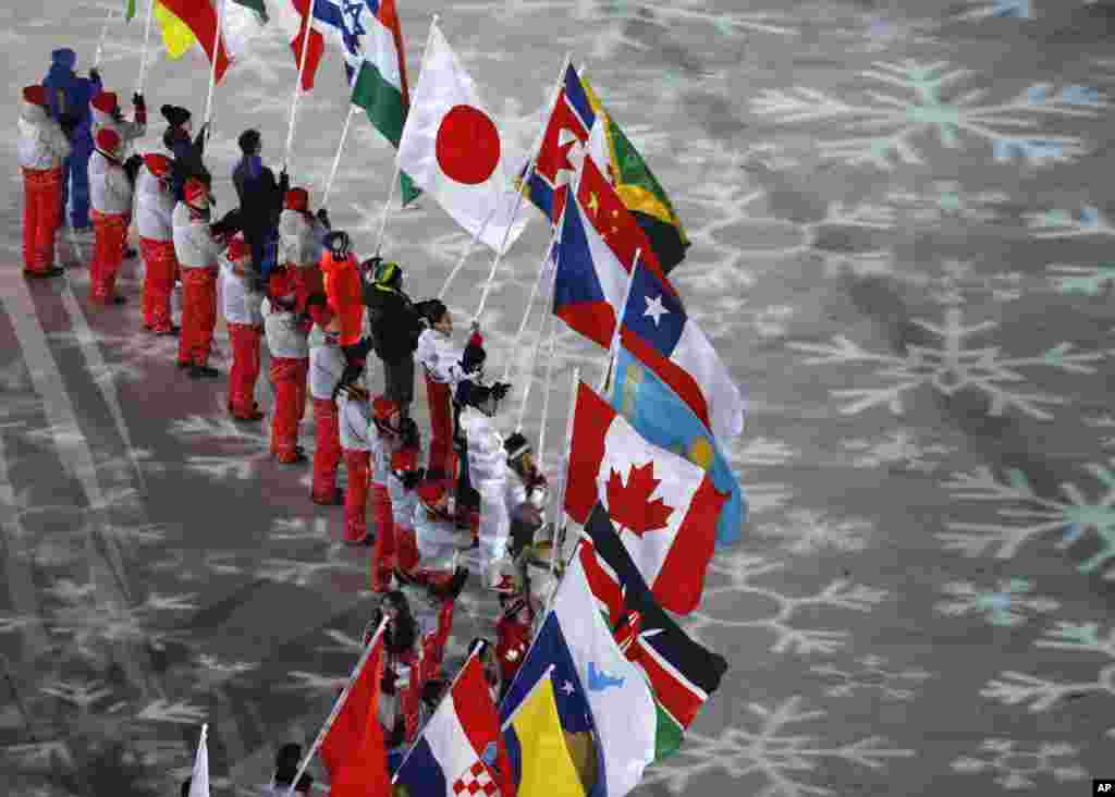 Qishki olimpiada yopilish marosimida ishtirokchi davlatlar vakillari bayroqlarini ko&#39;tarib chiqmoqda.