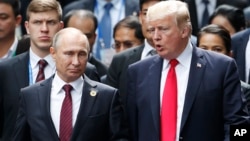Presiden Rusia Vladimir Putin (kiri) berbicara dengan Presiden AS Donald Trump di sela-sela KTT APEC di Danag, Vietnam, 11 November 2017.