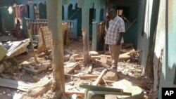 A man stands amid the debris at the scene of an attack in the town of Mandera, Kenya, near the border with Somalia, Oct. 25, 2016. 