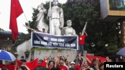 Protesters chant anti-China slogans while standing at a war martyrs monument during an anti-China protest in Hanoi, July 1, 2012.