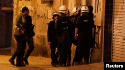 Bahraini riot police enter a house during a raid to arrest suspected protesters involved in clashes (file photo).