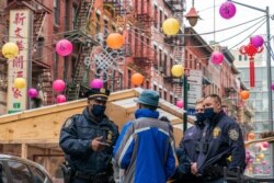 Capt. Tarik Sheppard, left, Commander of the New York Police Department Community Affairs Rapid Response Unit, speaks to a resident while on a community outreach patrol in the Chinatown neighborhood of New York, March 17, 2021.