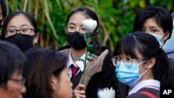 Mourners line up for a memorial service to pay their respects to Chow Tsz-lok, a student who died after falling off a parking garage when police fired tear gas during clashes in November, in Hong Kong, Dec.12, 2019. 